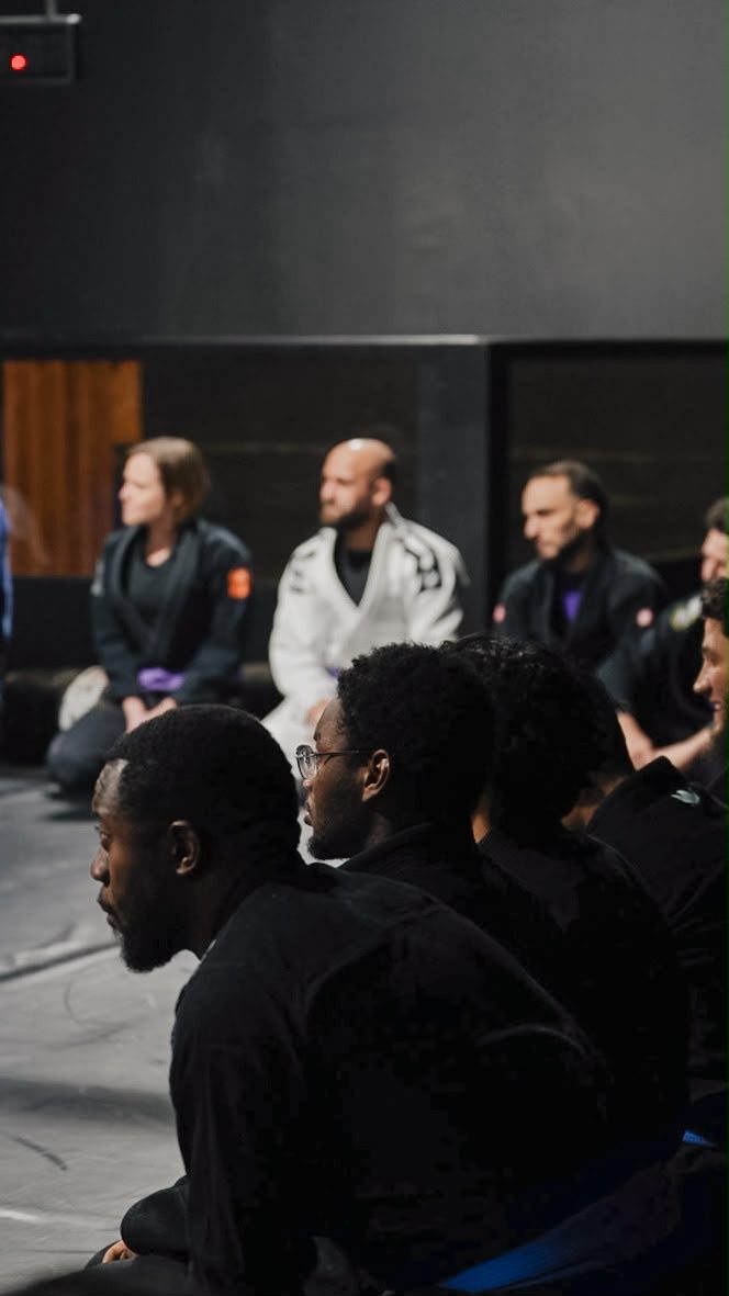 Élèves Invictus assis, à l'écoute du coach, ambiance feutrée de la salle